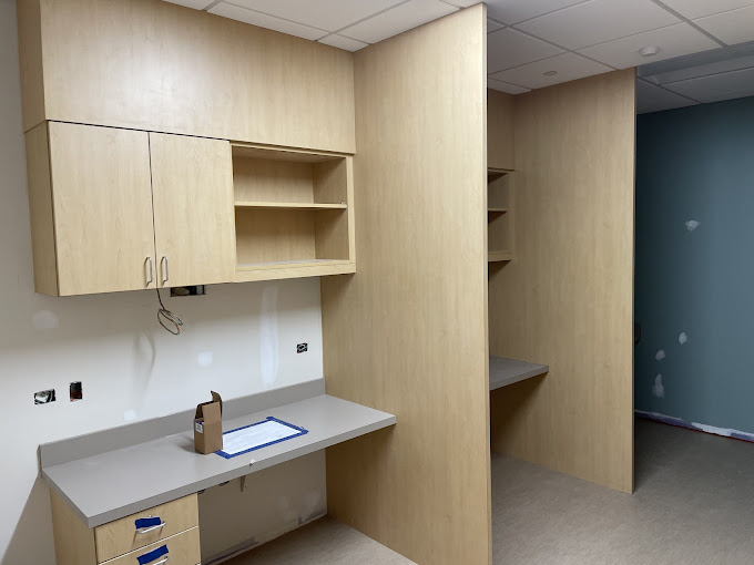 A room with a desk, cabinets, and a phone